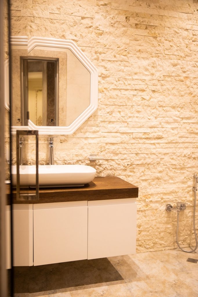 bathroom-with-gray-vanity-gray-cabinet-with-white-sink-white-gray-wallpaper